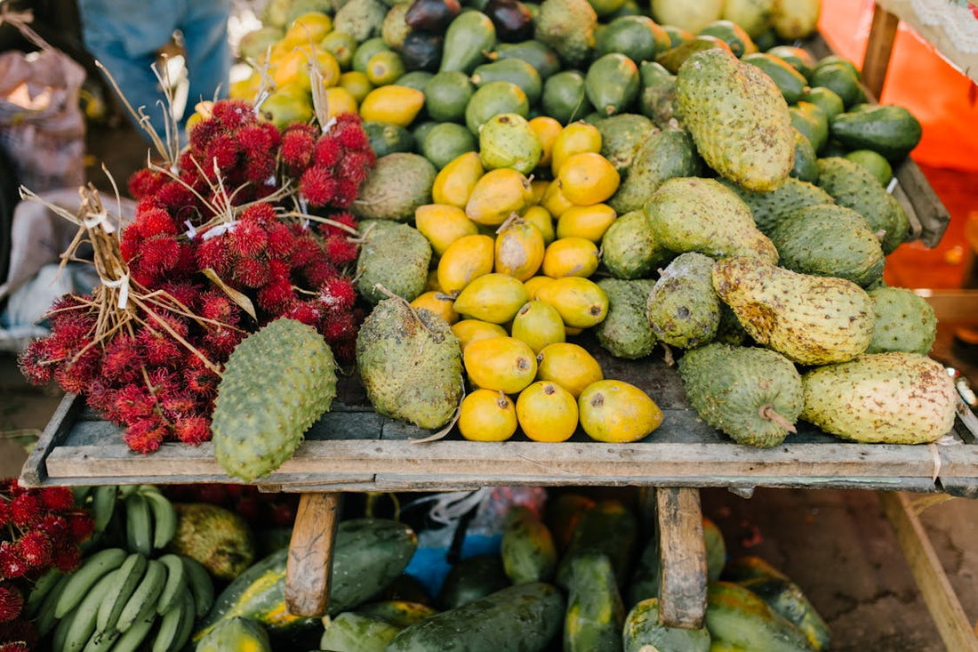 Várias frutas sob uma bancada, mostrando a graviola também